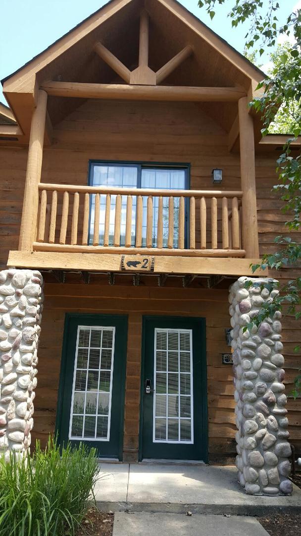 entrance to property featuring log siding and a balcony