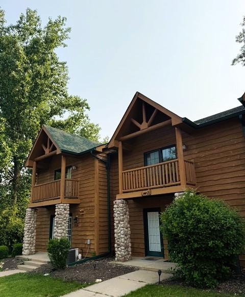 2643 N Il Route 178th Hwy Unit 2-2, Utica, IL 61373 - view of front of house featuring a balcony, stone siding, and central AC unit