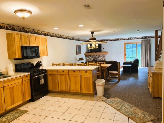 2643 N Il Route 178th Hwy Unit 2-2, Utica, IL 61373 - kitchen with black appliances, a peninsula, light countertops, ceiling fan, and light tile patterned flooring