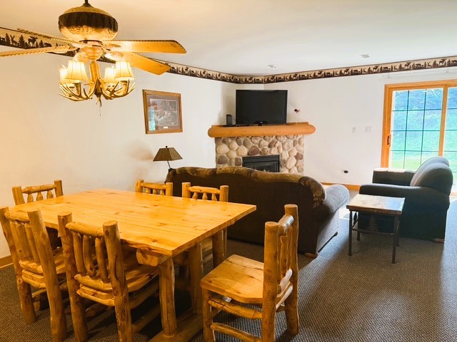 2643 N Il Route 178th Hwy Unit 2-2, Utica, IL 61373 - dining room with carpet, a stone fireplace, and a ceiling fan