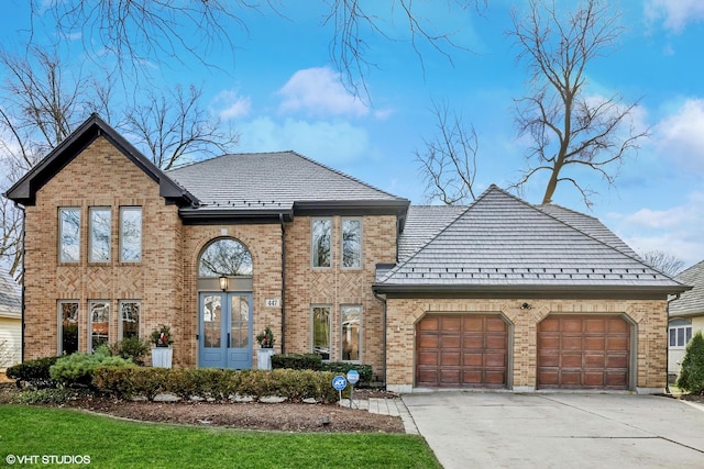 view of front of property featuring driveway, a garage, and brick siding