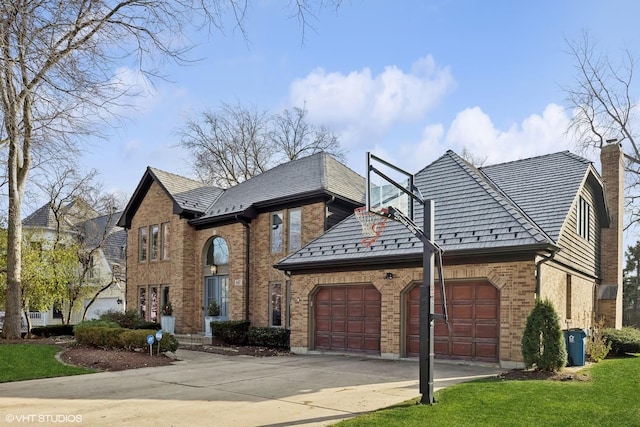 view of front of property with a garage, driveway, a chimney, a front lawn, and brick siding