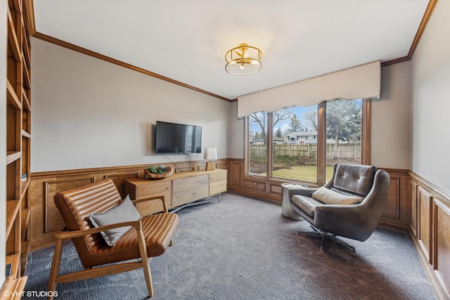 living area featuring carpet, ornamental molding, and wainscoting