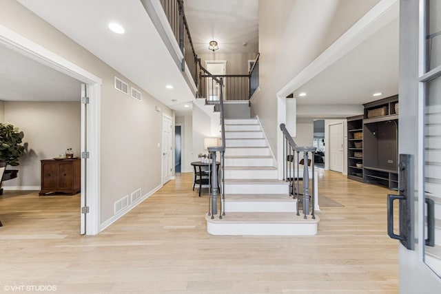 entryway featuring visible vents, stairway, and wood finished floors