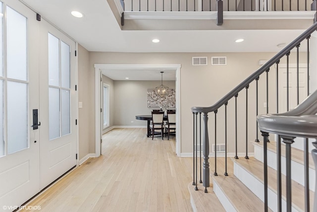 entryway with stairway, light wood-type flooring, visible vents, and recessed lighting