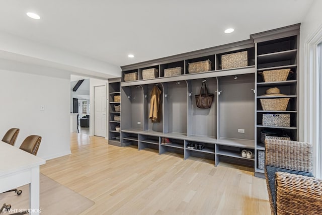 mudroom with built in features, recessed lighting, and light wood finished floors