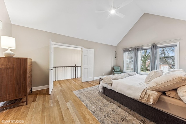 bedroom featuring light wood-style floors, high vaulted ceiling, baseboards, and a ceiling fan