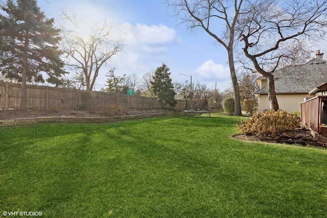 view of yard featuring a fenced backyard and a trampoline