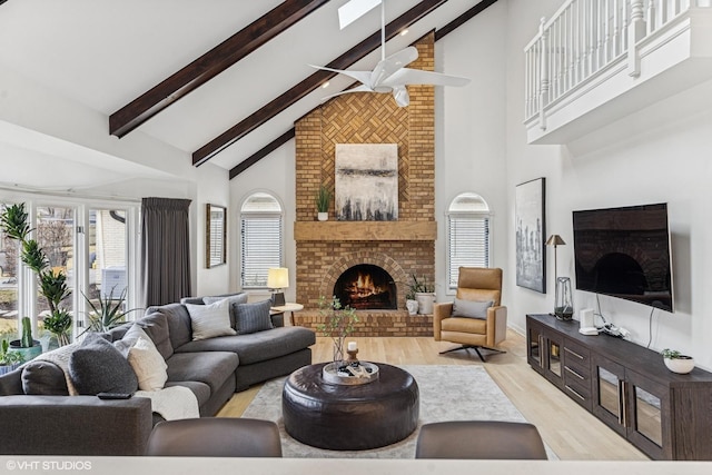 living room with high vaulted ceiling, light wood-type flooring, beam ceiling, and a fireplace