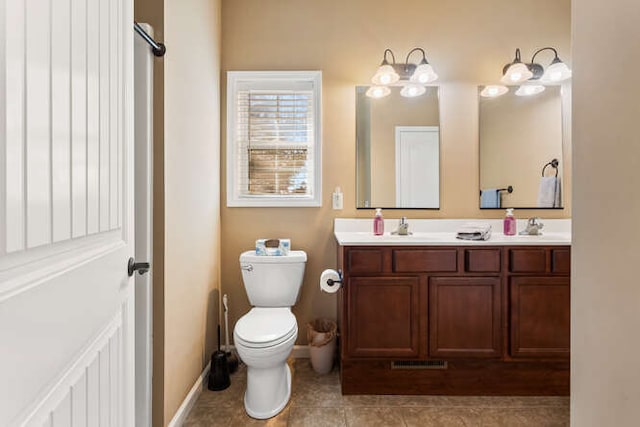 full bath featuring tile patterned flooring, double vanity, toilet, and a sink