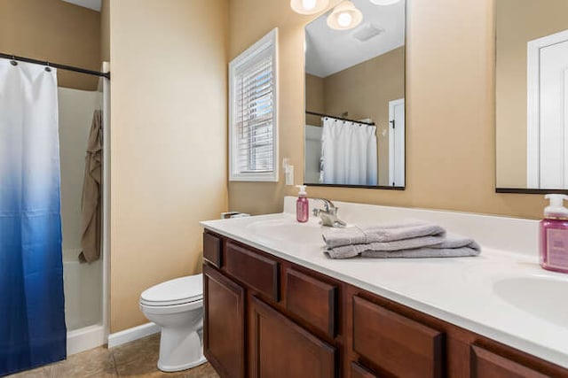 full bath with tile patterned flooring, curtained shower, toilet, double vanity, and a sink