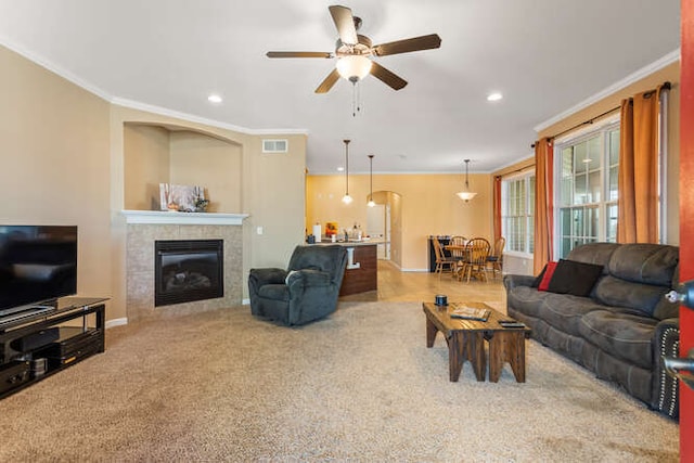 carpeted living area with crown molding, recessed lighting, and a fireplace