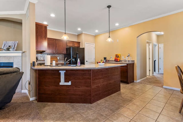 kitchen with tasteful backsplash, black fridge with ice dispenser, arched walkways, a peninsula, and light countertops