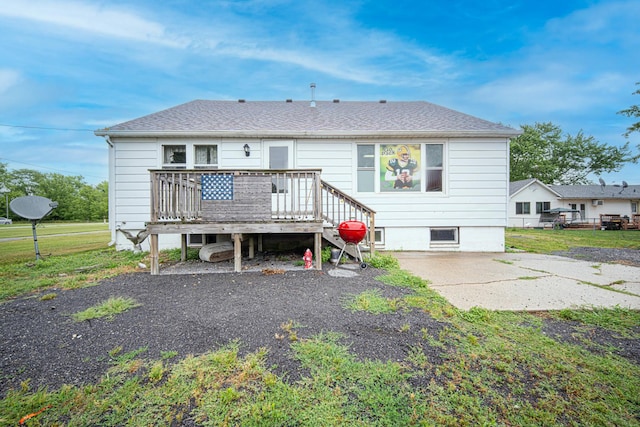 back of property featuring a deck and roof with shingles