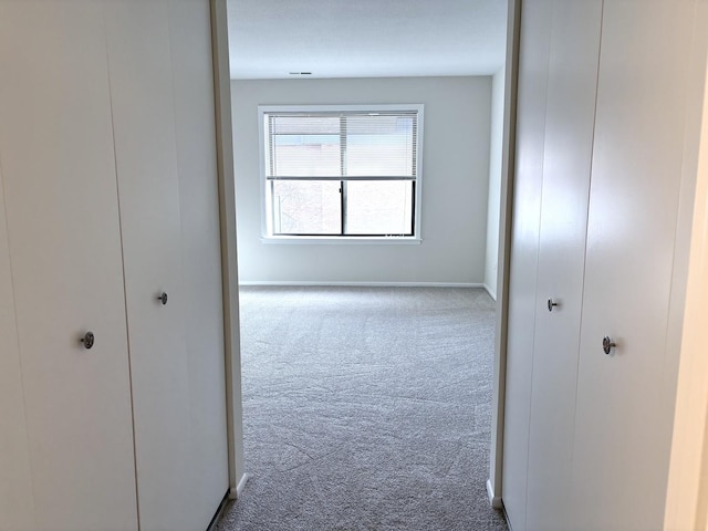 corridor featuring carpet floors and baseboards