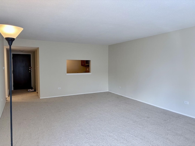 unfurnished room with baseboards and light colored carpet