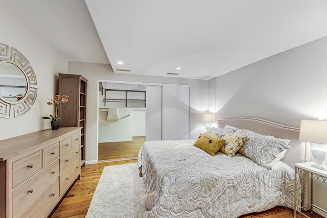 bedroom with visible vents, baseboards, recessed lighting, light wood-style floors, and a closet