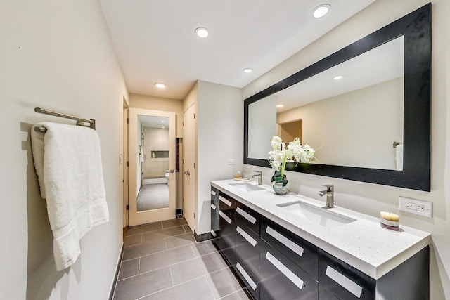 bathroom with a sink, double vanity, recessed lighting, and tile patterned flooring