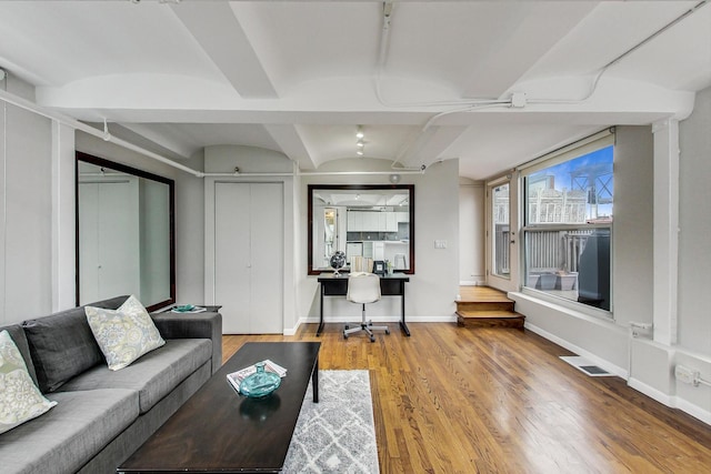 living room with visible vents, baseboards, and wood finished floors