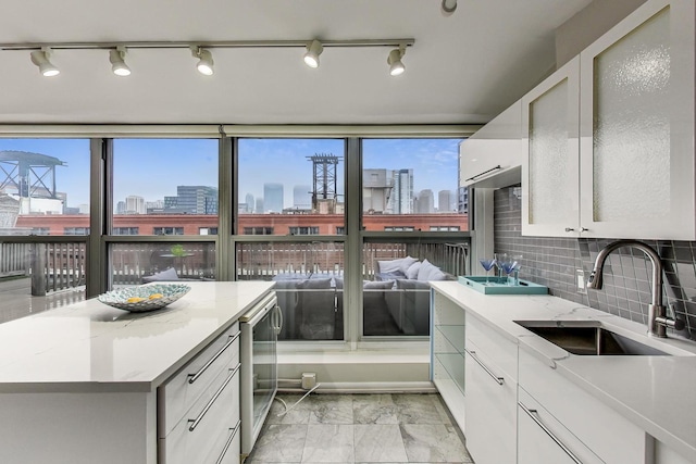 kitchen with wine cooler, a city view, a healthy amount of sunlight, and a sink