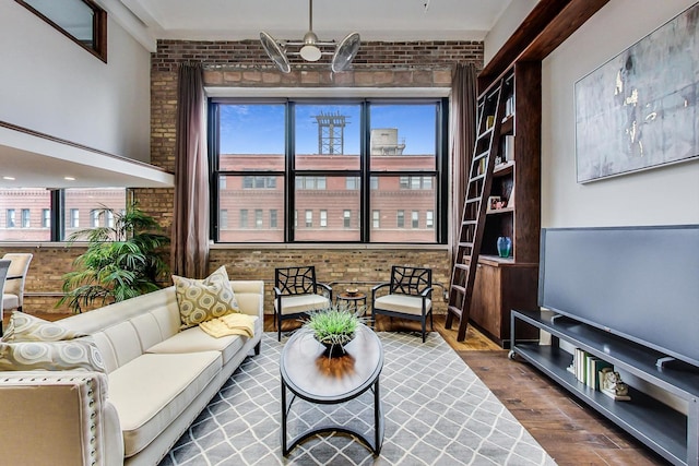 living area with dark wood-type flooring and brick wall