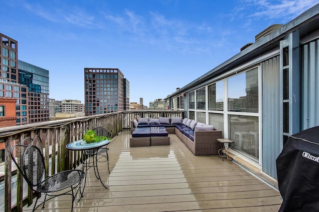 wooden deck featuring a view of city, a grill, and an outdoor hangout area