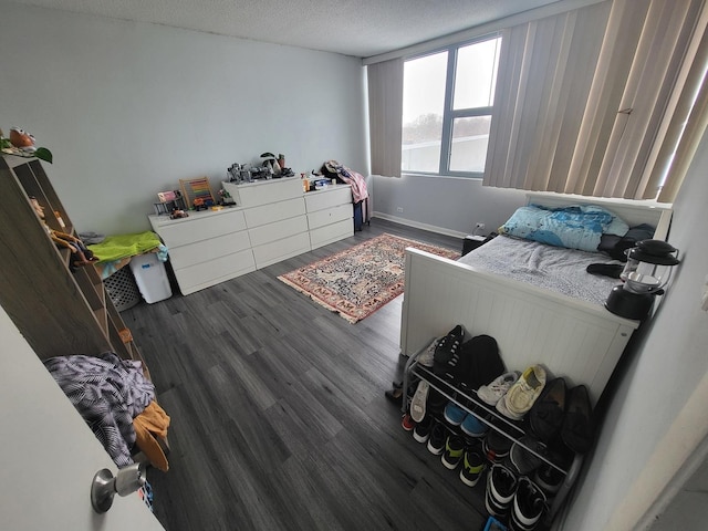 bedroom with a textured ceiling and dark wood-type flooring