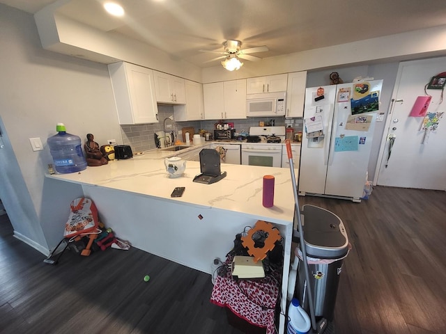 kitchen featuring white appliances, a sink, white cabinets, backsplash, and dark wood finished floors