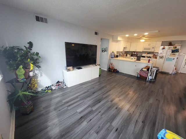 living area with dark wood-style floors, visible vents, ceiling fan, and a textured ceiling