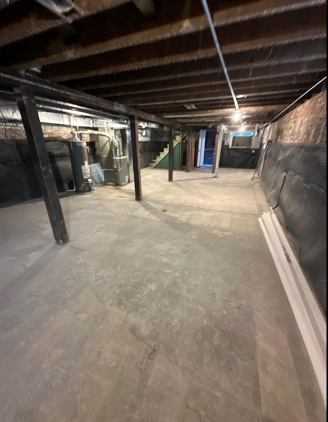 unfinished basement with water heater and heating unit