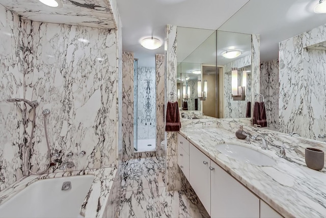 full bath featuring a bathtub, marble finish floor, tile walls, a marble finish shower, and vanity