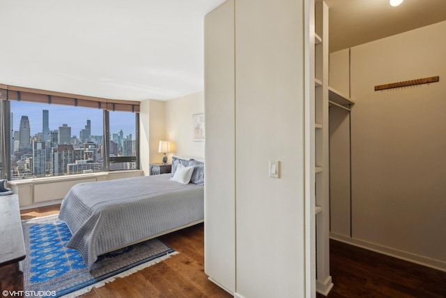 bedroom featuring a view of city and wood finished floors