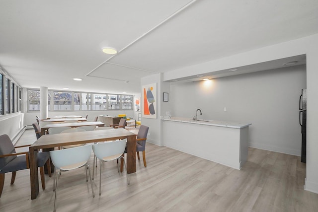 dining room with light wood-type flooring and baseboards