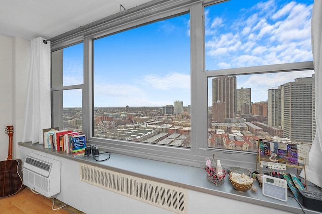 details with a view of city, an AC wall unit, wood finished floors, and radiator