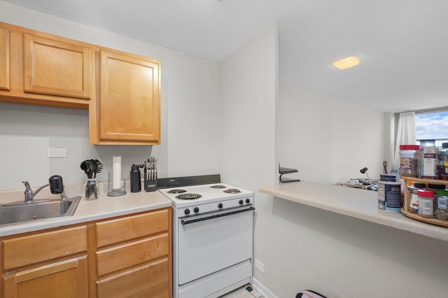 kitchen with electric range, light countertops, and a sink