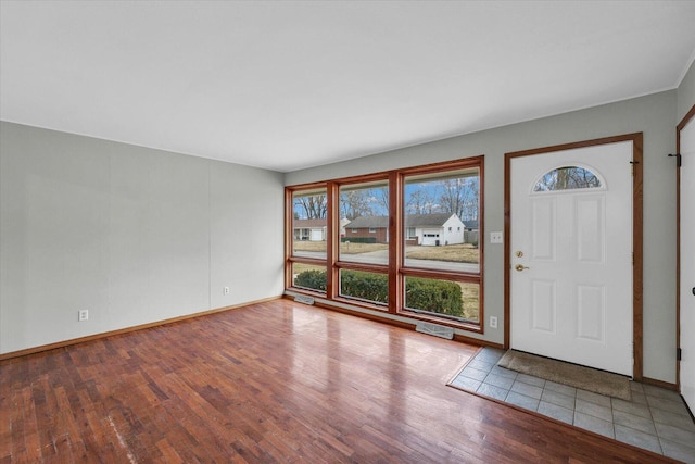 foyer with baseboards and wood finished floors