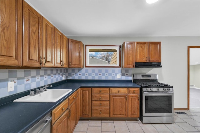 kitchen featuring brown cabinets, under cabinet range hood, stainless steel appliances, and a sink