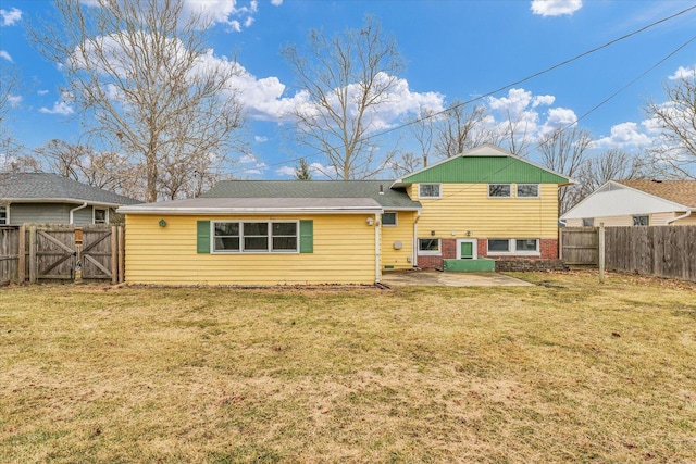 rear view of house with a patio, a fenced backyard, brick siding, a lawn, and a gate