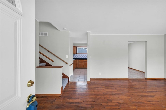 foyer entrance featuring light wood-style floors, visible vents, stairway, and baseboards