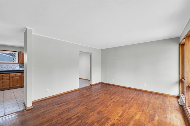 unfurnished room with baseboards and wood finished floors