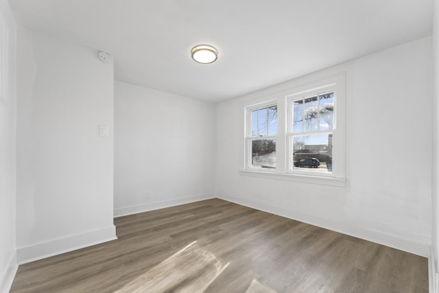 spare room featuring wood finished floors and baseboards