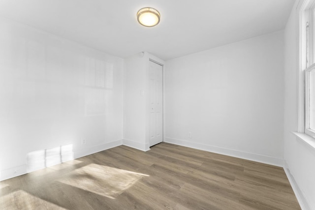 empty room with baseboards and wood finished floors