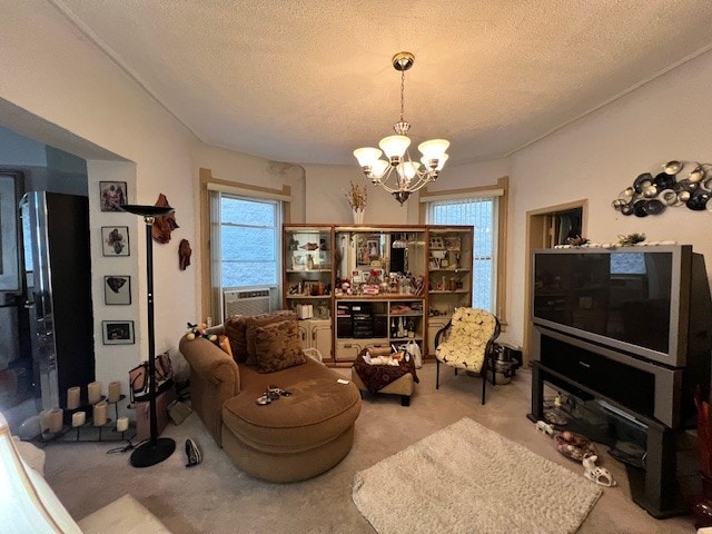 living area with cooling unit, a notable chandelier, a textured ceiling, and carpet