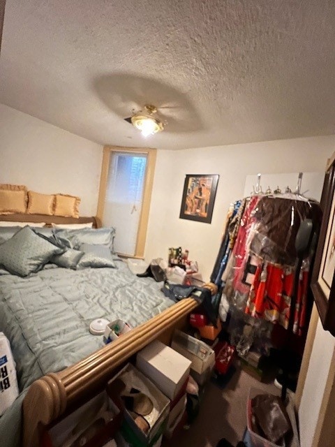 bedroom featuring a ceiling fan and a textured ceiling