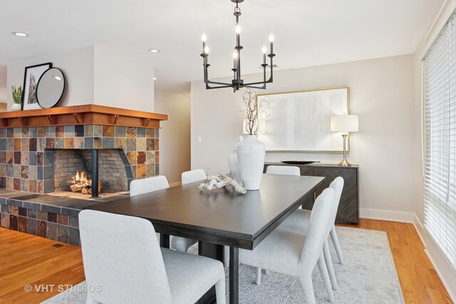 dining room with light wood finished floors, baseboards, a tile fireplace, a chandelier, and recessed lighting