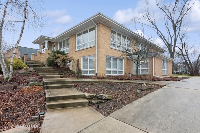 exterior space featuring stairs and brick siding