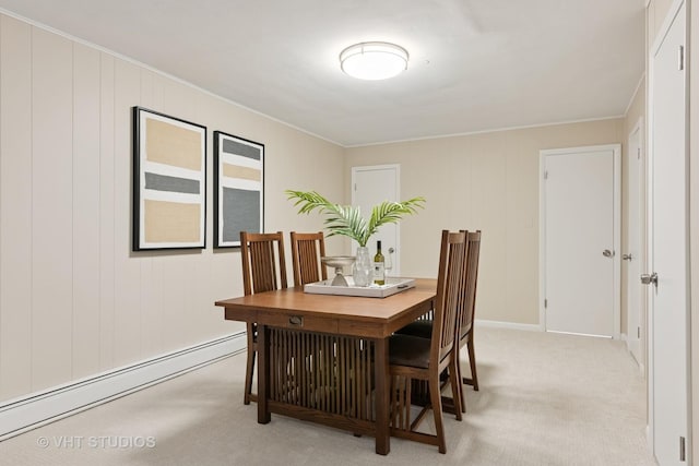 dining area with a baseboard heating unit and light colored carpet