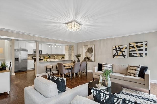 living room featuring baseboards, dark wood-style floors, and crown molding