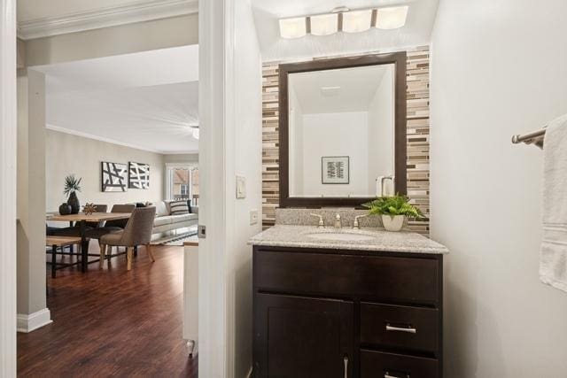 bar featuring a sink, dark wood finished floors, and crown molding