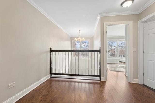 interior space with an inviting chandelier, baseboards, ornamental molding, and wood finished floors